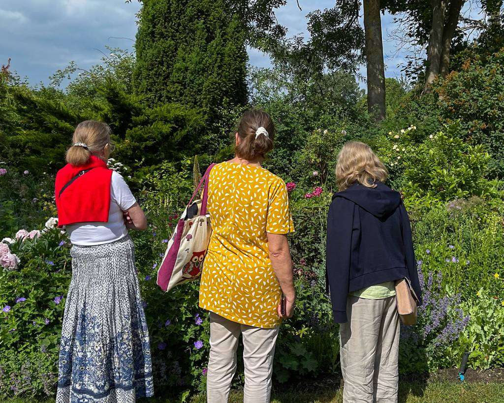 Glade kursister på havekursus i Blomsterhaven Deltagere på havevandring i Blomsterhaven, der betragter et farverigt staudebed