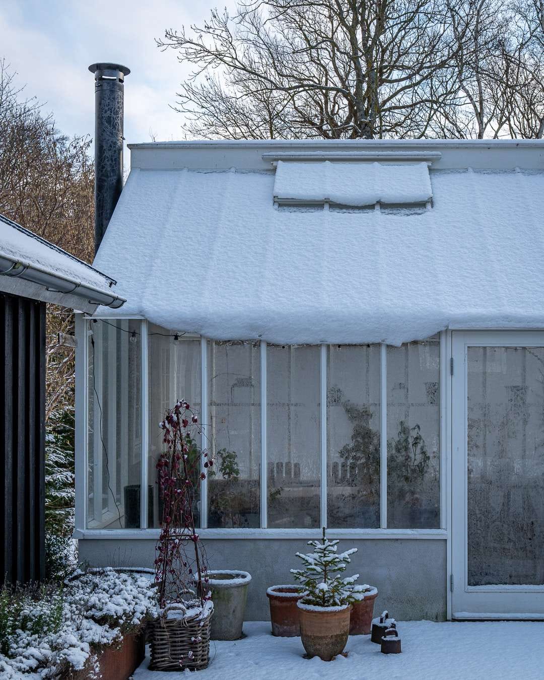 Brændeovn i drivhuset En brændeovn kan godt give et tilskud af varme på kolde dage