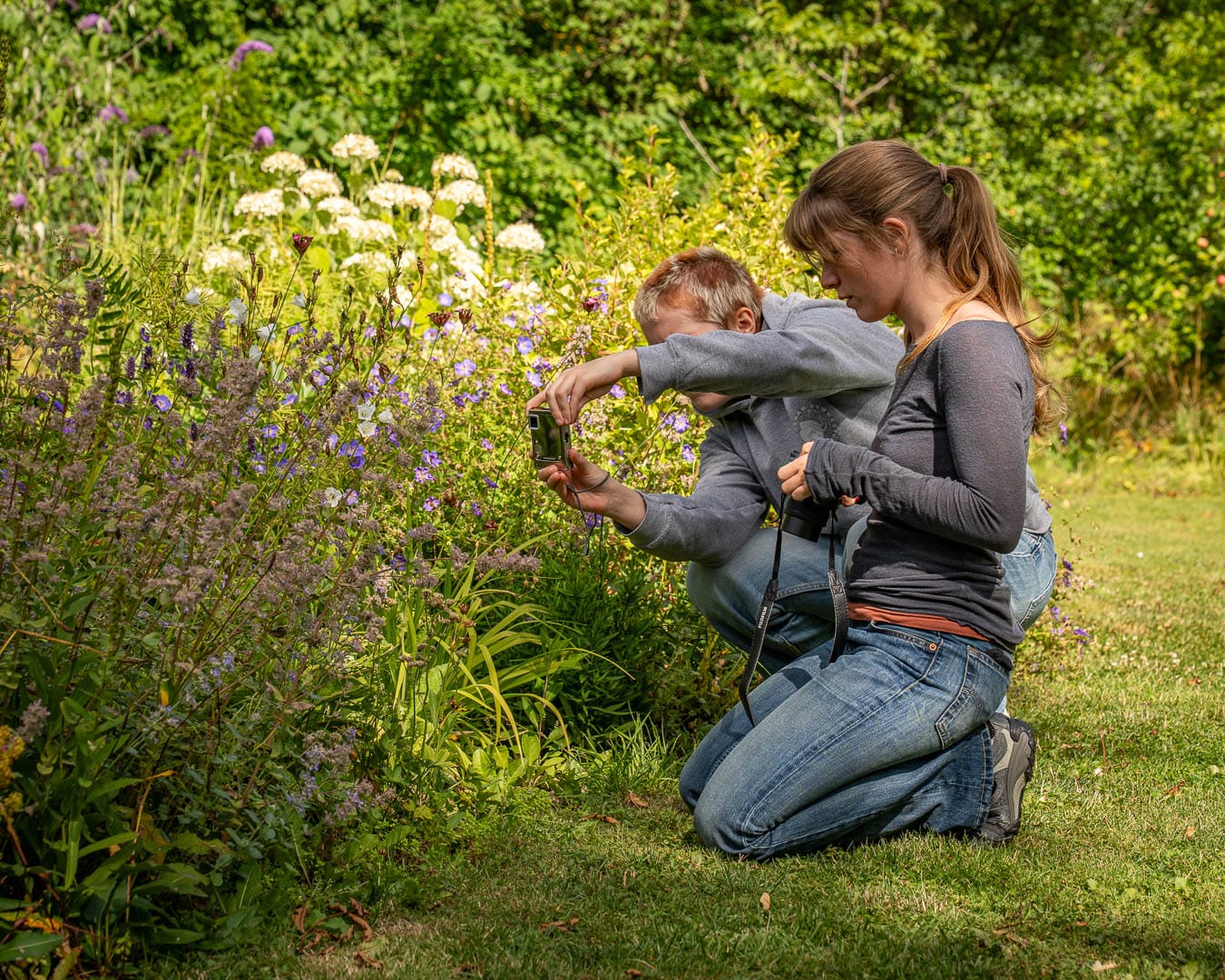 To deltagere fotograferer blomster tæt på under fotokursus i Blomsterhaven