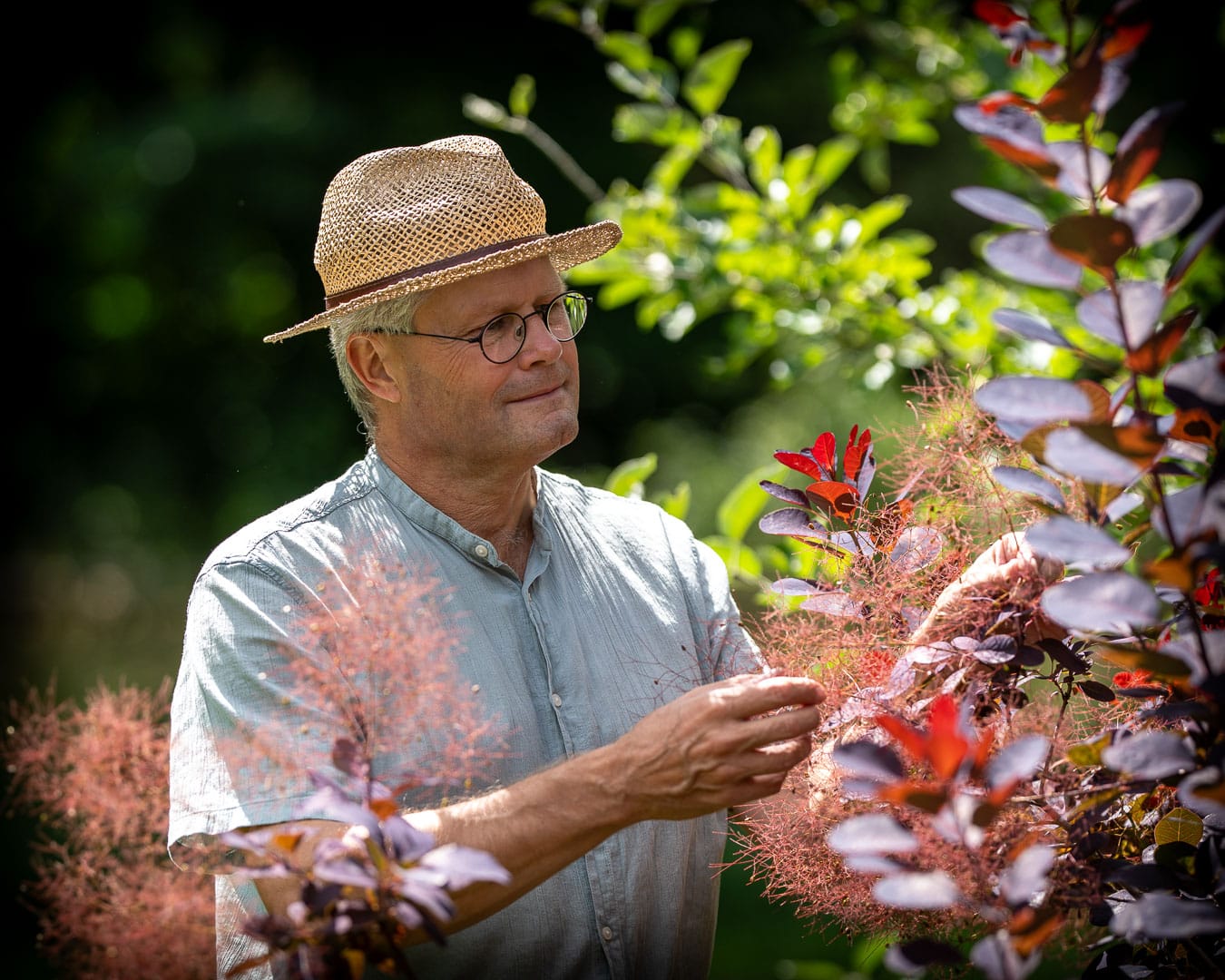 Kenn Römer-Bruhn i Blomsterhaven omgivet af blomster og farverige haverum