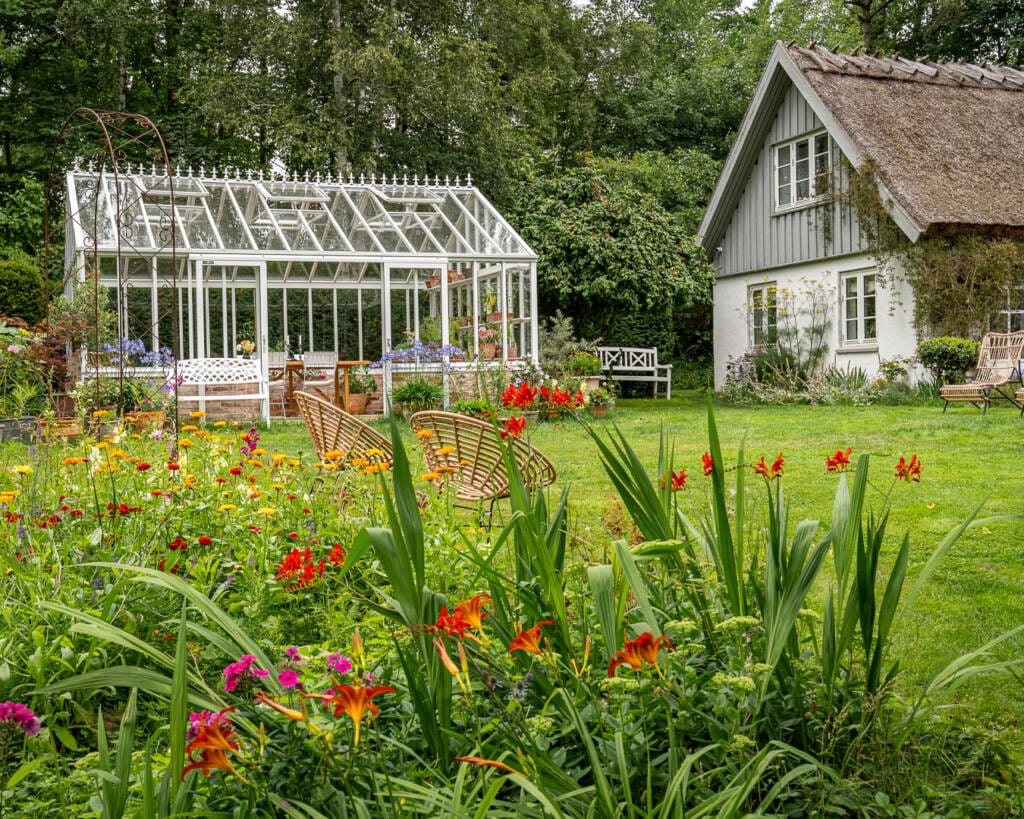 Det store drivhus passer til husets og havens stil Det store drivhus passer til husets og havens stil