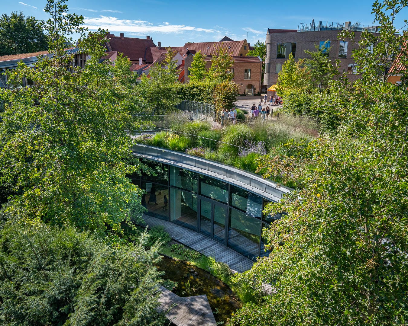 Nedsænket have med stauder, café og byhuse ved H.C. Andersen Haven i Odense.