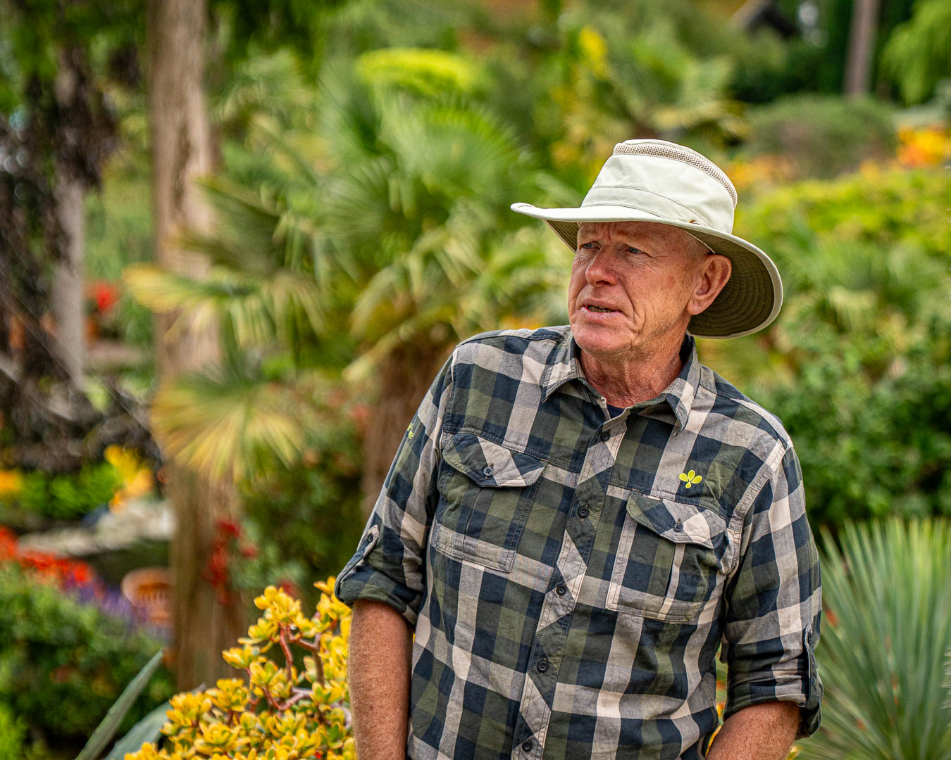 Olav Bryn med bredskygget hat i den frodige have på Flor & Fjære ved Stavanger i Norge